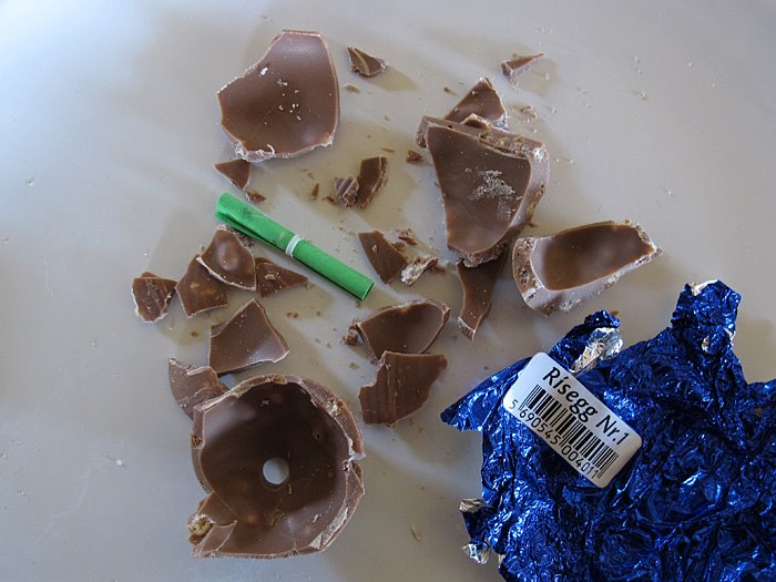 Reykjavík. Der grosse Schokoladen-Ostereier Test. - Ei 1: Um an den Inhalt des Eis' zu kommen musste ich die Schlokolade mit Kraftaufwand pressen (uff!). Die Schokolade zerfiel in viele kleine Bruchsrücke. Der Inhalt: eine kleine grüe Papierrolle! Der Geschmack der Schokolade: gut, schokoladig, und auch gut, weil die Schokolade mit Puffreis vermischt ist. (Ostern 2012)